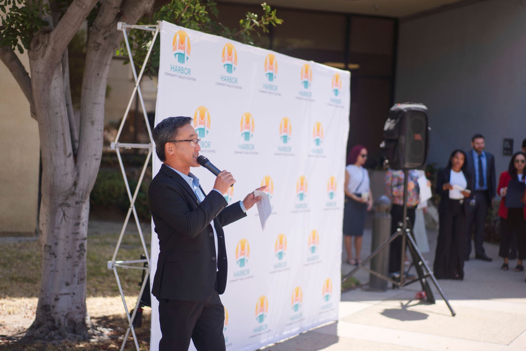 Stuart Takehara speaks to community members at the Harbor Community Health Centers grand opening