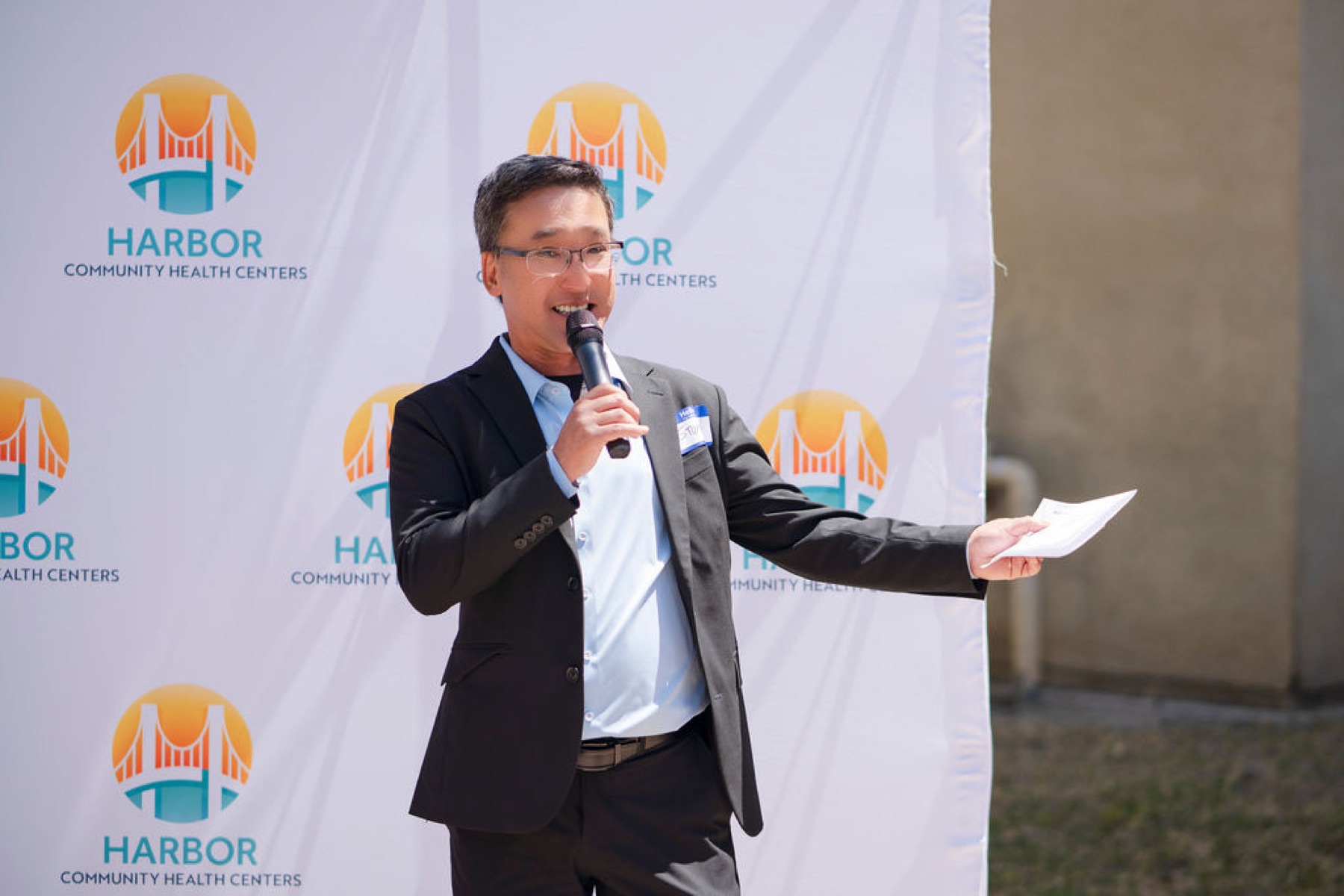 Stuart Takehara welcomes guests during the Harbor Community Health Centers grand opening in Long Beach